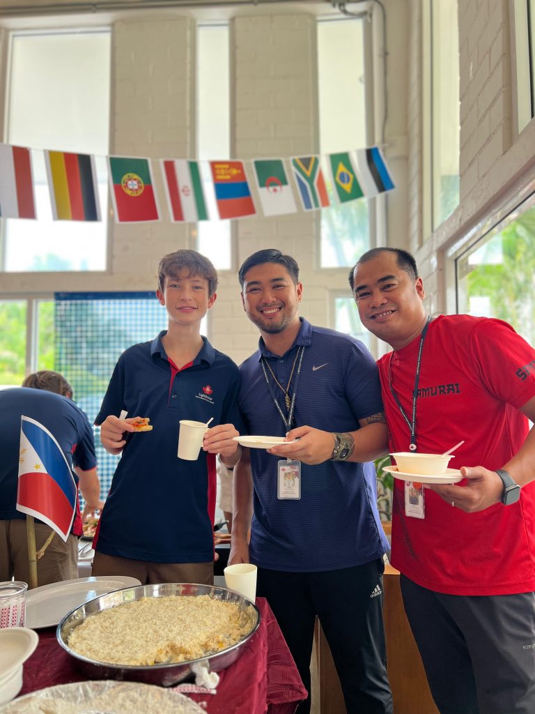 A photo of a student and teachers posing with food