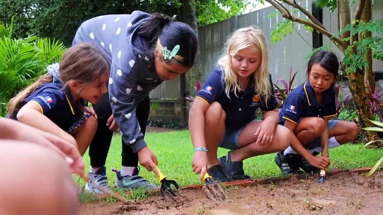 Girls planting with teacher